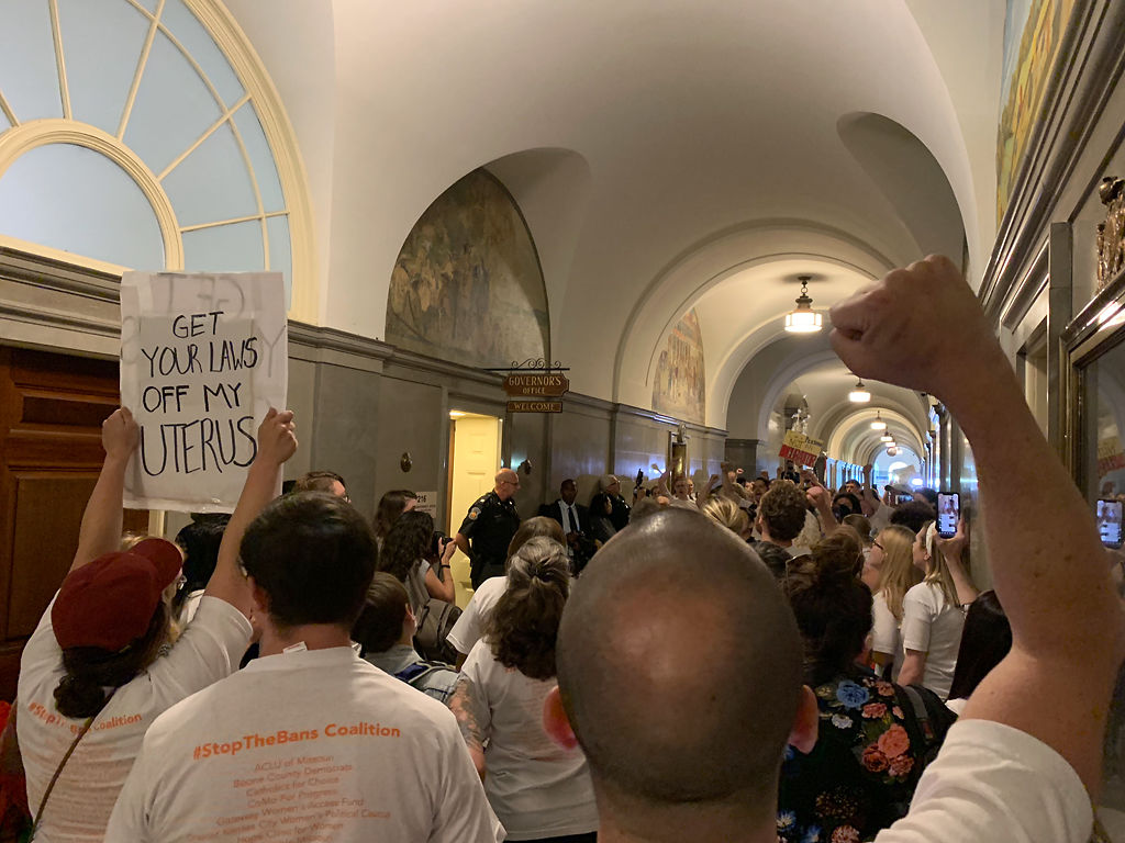 Protestors gather outside the governor’s office, chanting 'veto'